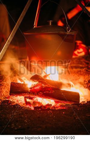 boiling pot over an open fire on a blurred background.