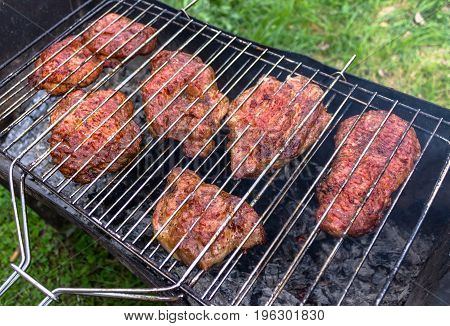 Meat, cooking steaks on open fire in the open air