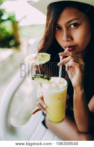 Young Beautiful Woman Drinking Cocktail With Pineapple In Beach Bar