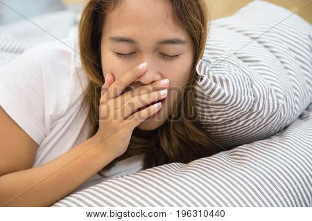 Young asian woman sleeps comfortably on the bed, Young asian woman are yawning on the bed