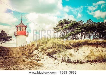 Retro style image of lighthouse Gellen on a grassy dune. Sunny summer day. Hiddensee, Germany. Baltic Sea.