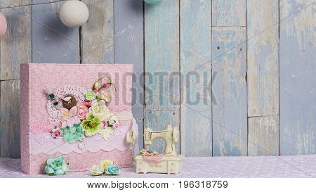 a photo album in the style of shabby chic on a blue background.