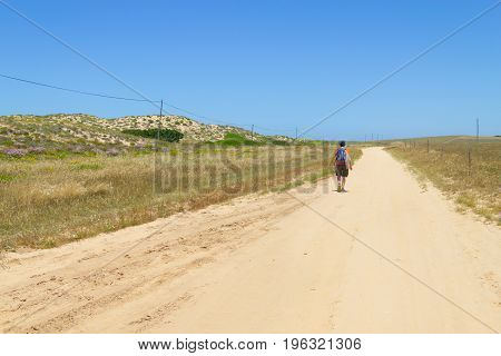 Girl hiking in sand road in Porto Covo Alentejo Portugal