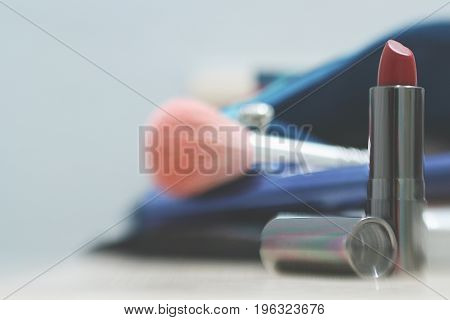 Make Up Vanity 1: makeup and a small bag litter a counter top, shallow depth of field gives a blurred background to the photo