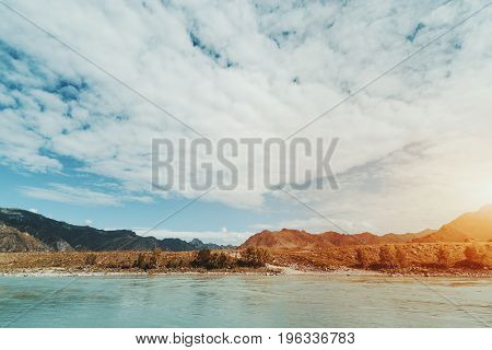 Wide angle view of beautiful scenery: mountain river Katun in foreground and mountains and hills of Altai in background on summer summer morning with dramatic cloudscape Kuyus district Russia
