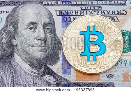 Golden blue bitcoin on one hundred bankmote background. High resolution photo.
