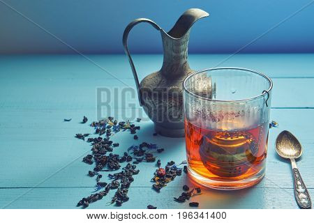 Vintage Shot Of Tea Glass With Strainer, Jug, Teaspoon And Leaves