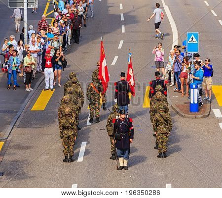 Zurich, Switzerland - 1 August, 2016: participants of the parade devoted to the Swiss National Day passing along Uraniastrasse street. The Swiss National Day is the national holiday of Switzerland, celebrated on 1 August.
