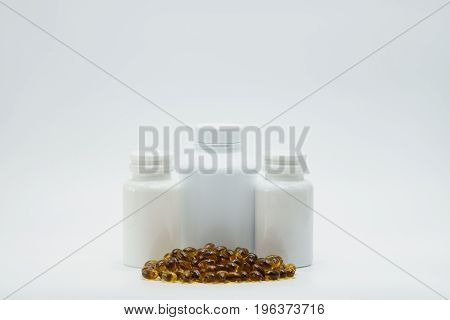 Brown capsule pill with closed bottle on white background