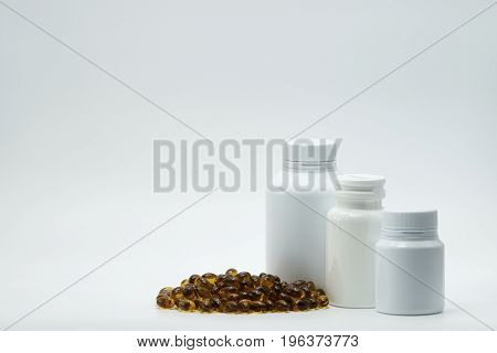 Brown capsule pill with closed bottle on white background