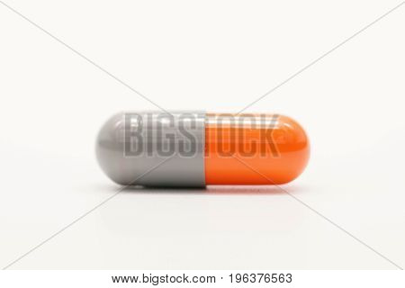 Grey orange medicine capsule isolated on white background