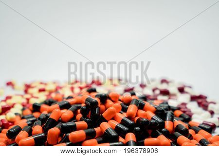 Orange black white red pale yellow capsule pills