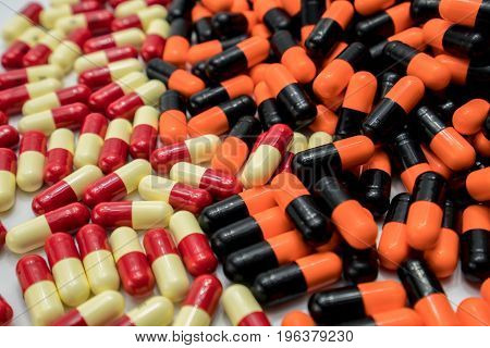 Orange black red pale yellow capsule pills