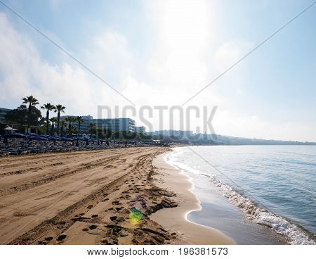 Soft Wave Of Blue Ocean On Sandy Beach. Background. Selective focus. Beach in the morning at sunrise in Ayia Napa on the island of Cyprus. Tropical beach. Summer background.