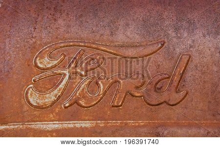 ISABEL, SOUTH DAKOTA, June 22, 2017: The rusty Ford  tractor hood logo is a product of the Ford Motor Company located in Dearborn, Michigan started by Henry Ford and incorporated on June 16, 1903