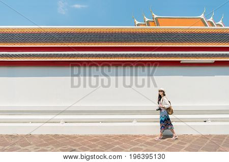 Woman tourist walking in Wat Pho temple Bangkok popular famous location of city travel destination. chinese girl visiting and looking around the sightseeing building architecture.