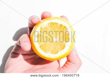 A man holds a slice of lemon for juice