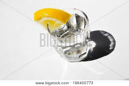 A glass of alcohol with a lemon for a snack