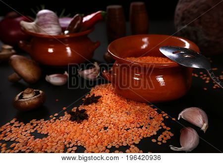 Raw vegetables and lentils on a black background