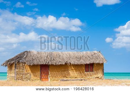 Colorful adobe house next to the sea under blue sky
