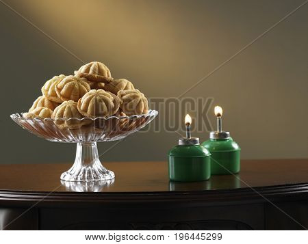 malay tradition food bahulu on the glass plate and oil lamp at the side