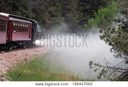 red vintage steam train spewing steam mountain