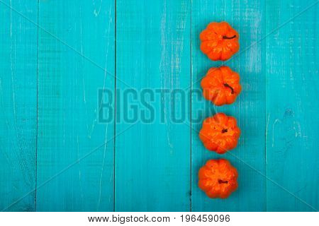 A Close Up Of Several Small Pumpkins Lined Up In A Row On Rustic Old Wooden Boards Against Medium Br