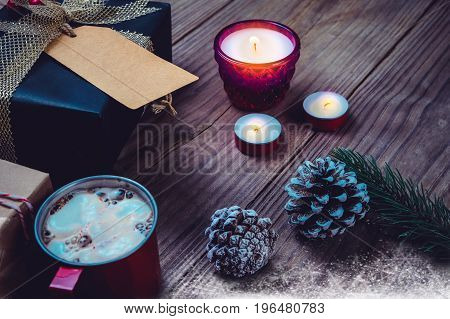 Christmas background with handmade present gift boxes and rustic decoration with candle hot chocolate on wood table in christmas night party. vintage color style.
