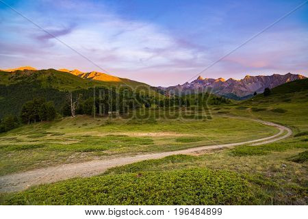 Dirt Mountain Road Leading To High Mountain Pass In Italy. Expasive View At Sunset, Colorful Dramati