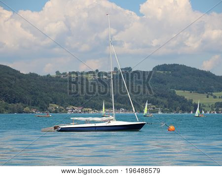 Sailing Ship on Blue Water with Mountain Forest in Background