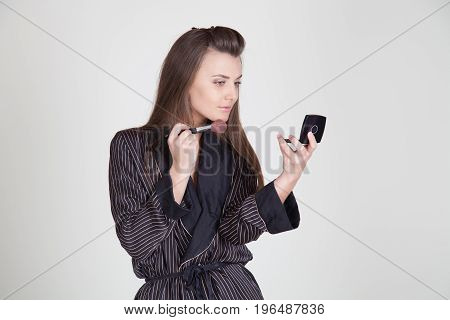 Girl In Coat Makes Brush Makeup Looks In The Mirror