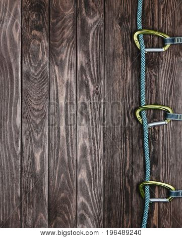 Climbing rope with quickdraws on a wooden background top view. Copy-space.