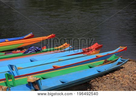 head of colorful long-tailed boats at riverside.