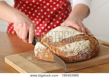 Woman Slicing Mixed Grain Bread. Selective focus.