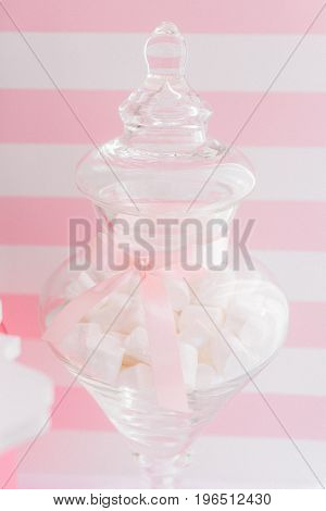 Transparent vase with marshmallows decorated with pink ribbon