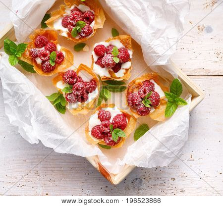 Phyllo cups with Mascarpone cheese  filling topped with fresh raspberries and mint, top view