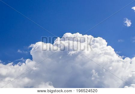 a big and fluffy cumulonimbus cloud in the blue sky.