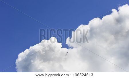 a big and fluffy cumulonimbus cloud in the blue sky.