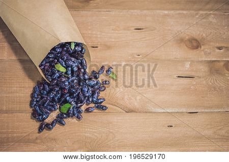Fresh Honeysuckle Blue Berry Fruits With Leaf On A Wooden Background