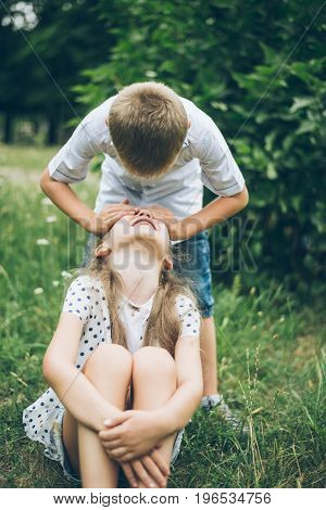 kids playing in the park, guess who, closing each other eye, siter and brother