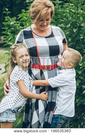 Grandmother playing in the park with grandchildren, siter with brother