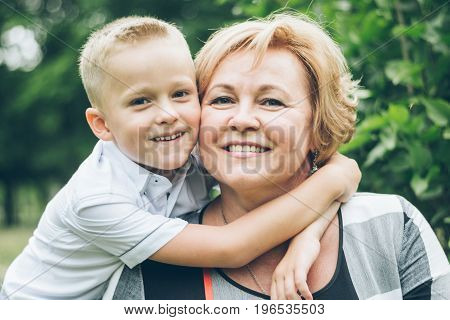 Grandmother playing in the park with grandchildren, siter with brother