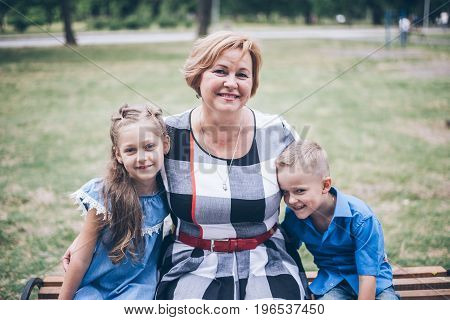 Grandmother playing in the park with grandchildren, siter with brother