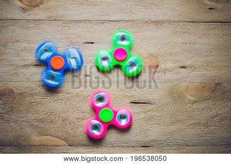 Colored Fidget Spinners Stress Relieving Toy On Wooden Background