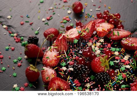 Fresh fruit and berry tart dessert dark stone background. Delicious sweet cake with raspberries strawberries blackcherry and cream.