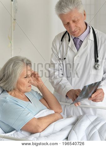 senior doctor showing radiograph to senior female patient in the hospital