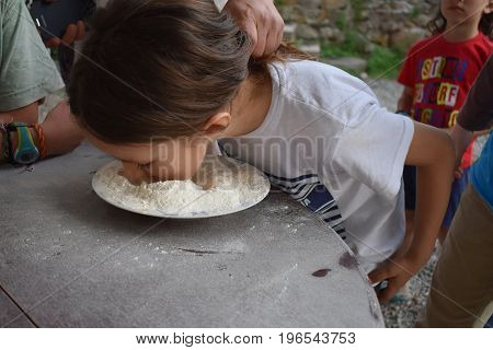 Child plays fetch a prize in a bowl of flour