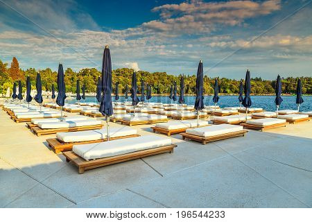 Sun loungers and beach umbrellas on the tropical beach Rovinj Istria region Croatia Europe