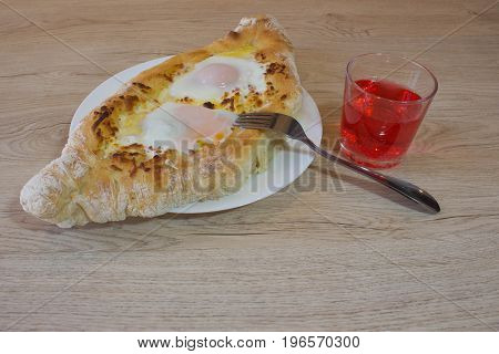 Adjarian khachapuri with eggs on the table. Delicious homemade khachapuri in Adjarian
