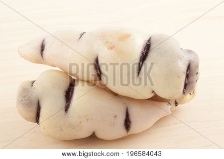 Cubios (Tropaeolum tuberosum) on light wooden background